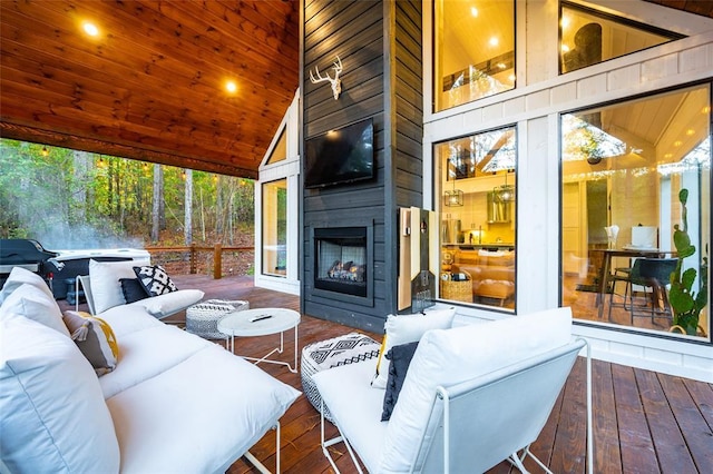 interior space with a large fireplace, high vaulted ceiling, hardwood / wood-style floors, and plenty of natural light