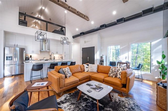 living room with light hardwood / wood-style floors, wooden ceiling, and high vaulted ceiling