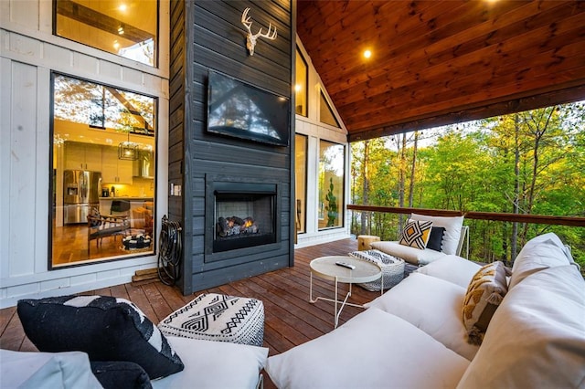 sunroom / solarium with a large fireplace, wooden ceiling, and lofted ceiling