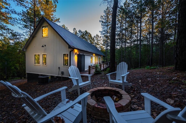 back house at dusk featuring an outdoor fire pit