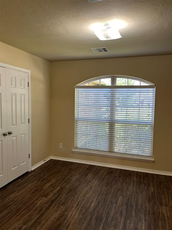 empty room featuring dark hardwood / wood-style flooring and a textured ceiling