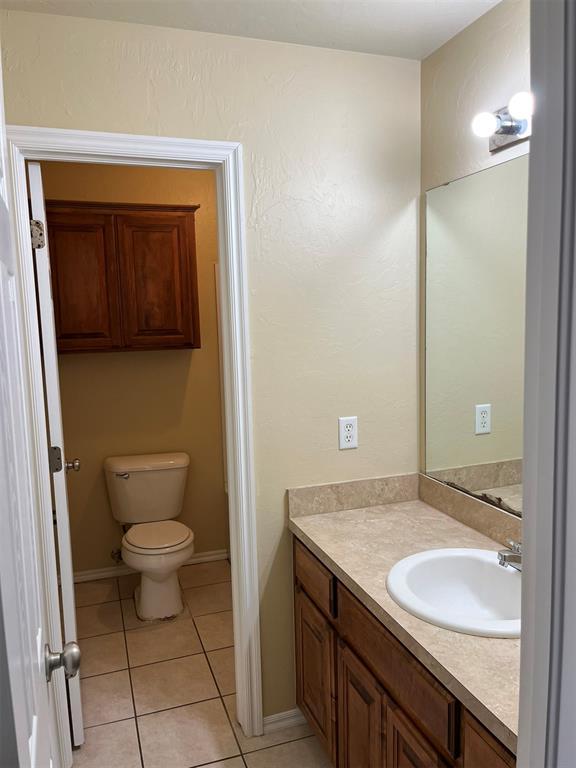 bathroom with tile patterned floors, vanity, and toilet