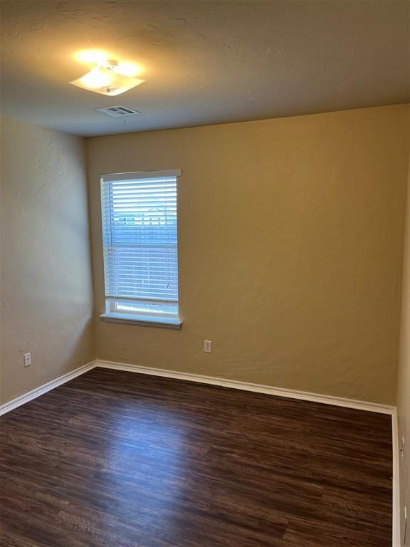 spare room with dark wood-type flooring