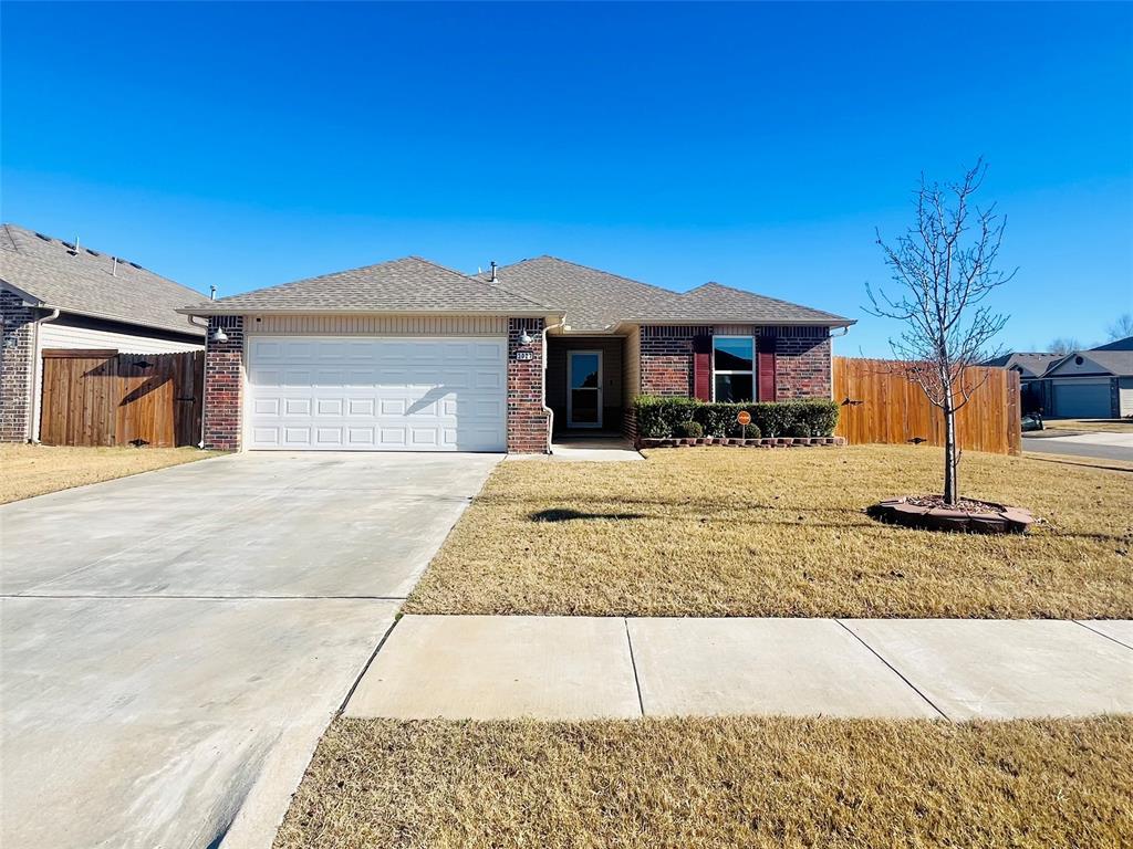 single story home featuring a garage and a front lawn