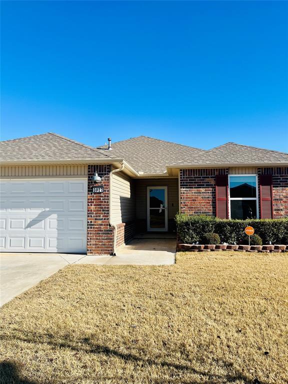 ranch-style home with a front lawn and a garage