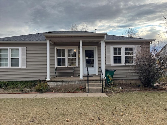 view of front of home with a porch and a front yard