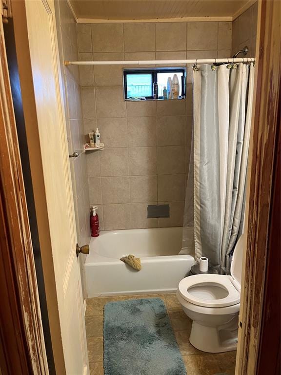 bathroom featuring shower / tub combo, tile patterned flooring, and toilet