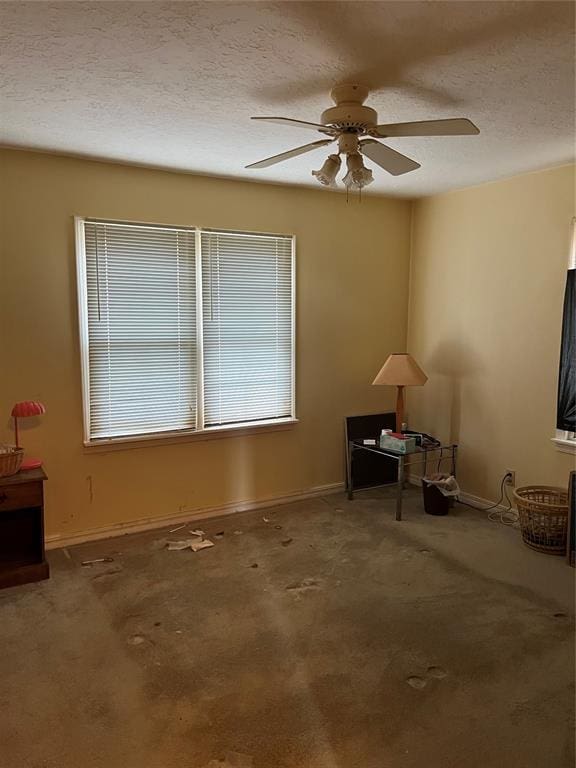 carpeted empty room featuring ceiling fan and a textured ceiling