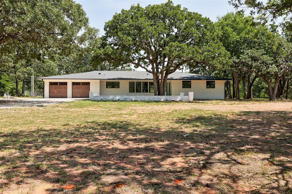 single story home featuring a garage and a front lawn