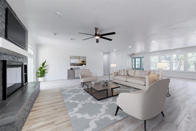 living room with ceiling fan and light hardwood / wood-style flooring