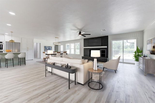 living room featuring ceiling fan and light hardwood / wood-style floors