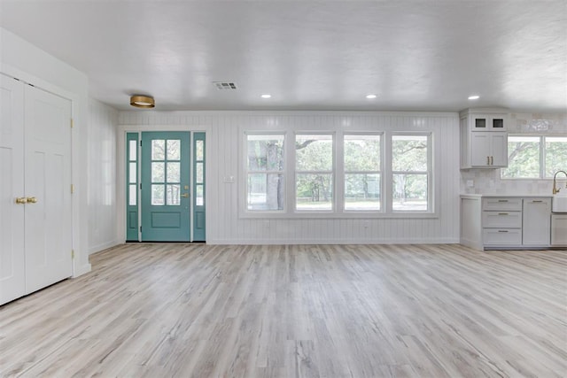 unfurnished living room with light wood-type flooring and a wealth of natural light