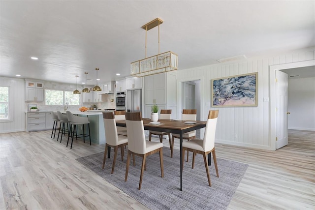 dining area featuring sink and light hardwood / wood-style floors