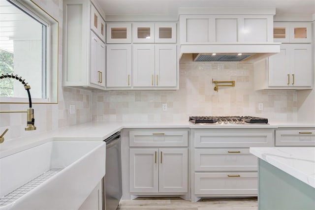 kitchen with decorative backsplash, appliances with stainless steel finishes, light stone counters, sink, and white cabinetry