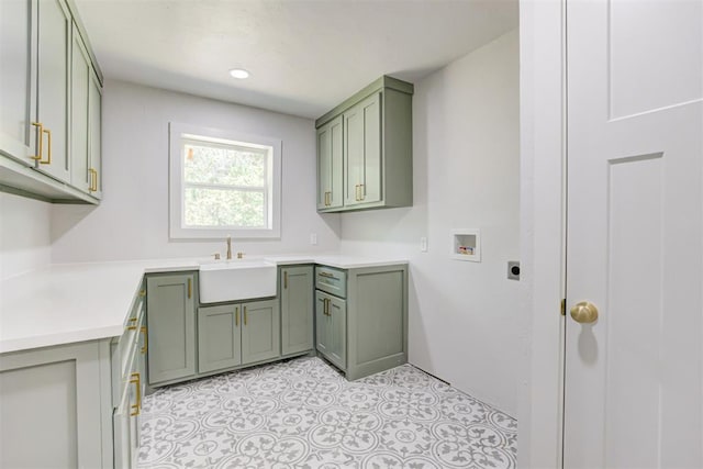 laundry area with hookup for an electric dryer, hookup for a washing machine, cabinets, and sink