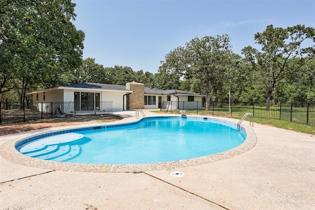 view of swimming pool with a diving board