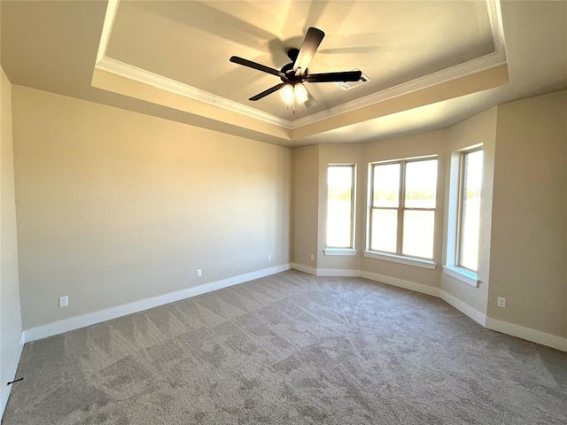 carpeted empty room featuring a tray ceiling, ceiling fan, and ornamental molding