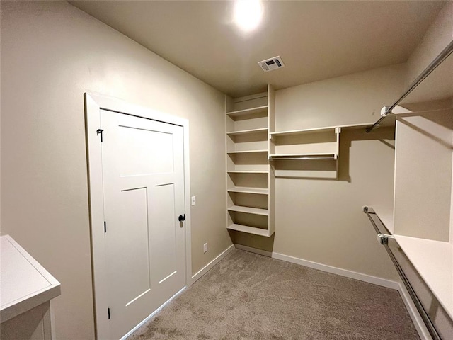 walk in closet featuring light carpet