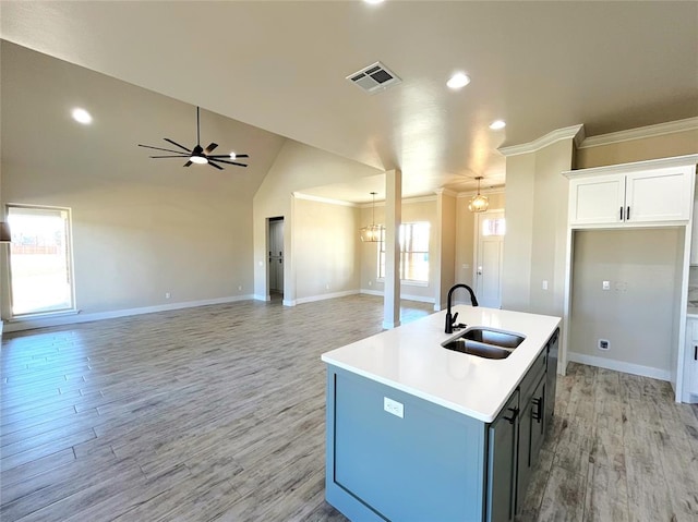 kitchen featuring white cabinets, ceiling fan with notable chandelier, sink, an island with sink, and light hardwood / wood-style floors