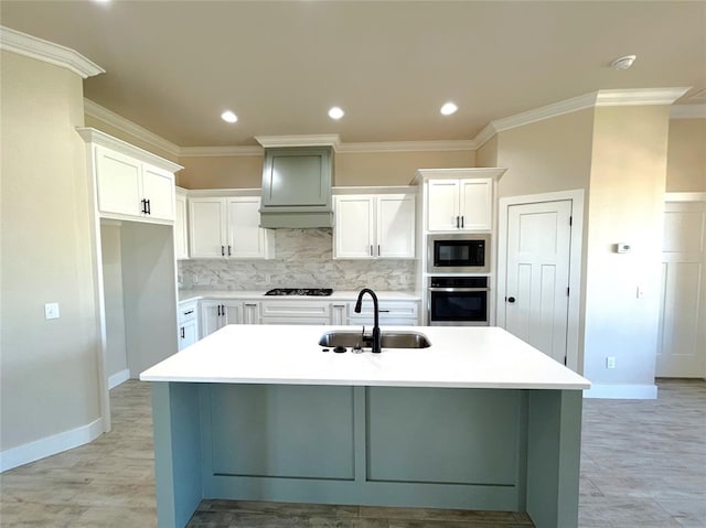 kitchen with stainless steel oven, a center island with sink, sink, built in microwave, and white cabinetry