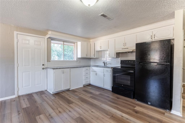 kitchen featuring white cabinets, light hardwood / wood-style floors, tasteful backsplash, and black appliances