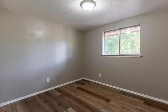 spare room featuring hardwood / wood-style floors and a textured ceiling