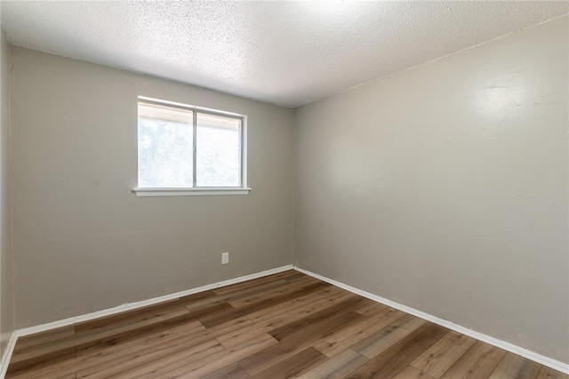 empty room featuring wood-type flooring and a textured ceiling