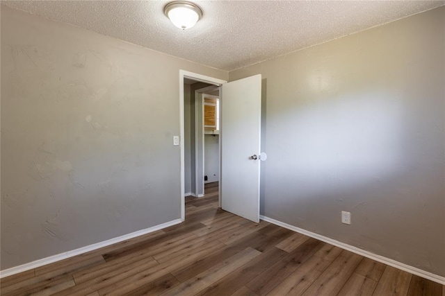 empty room featuring hardwood / wood-style floors and a textured ceiling