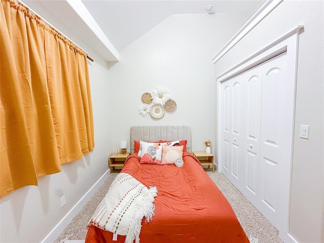 bedroom with a closet, carpet floors, and vaulted ceiling