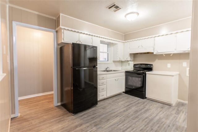 kitchen featuring sink, crown molding, white cabinets, black appliances, and light wood-type flooring