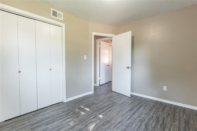 unfurnished bedroom featuring dark hardwood / wood-style flooring and a closet