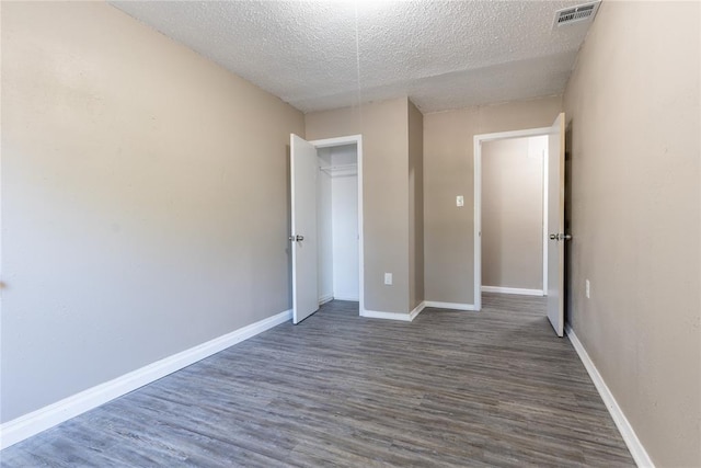 unfurnished bedroom featuring a textured ceiling and dark wood-type flooring