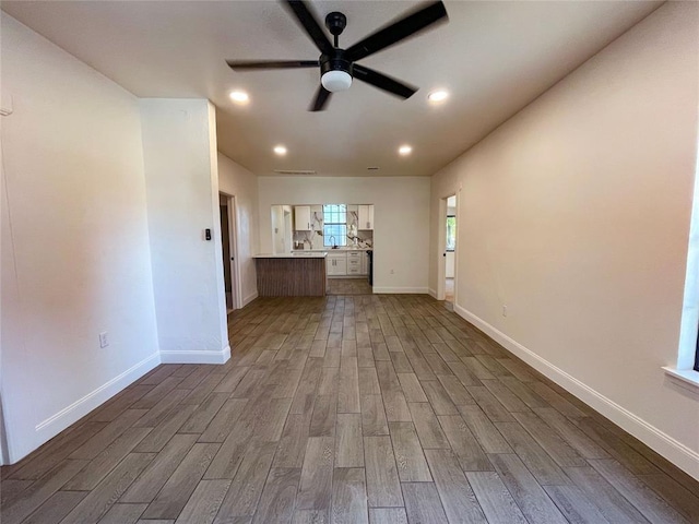 unfurnished living room featuring dark hardwood / wood-style floors and ceiling fan