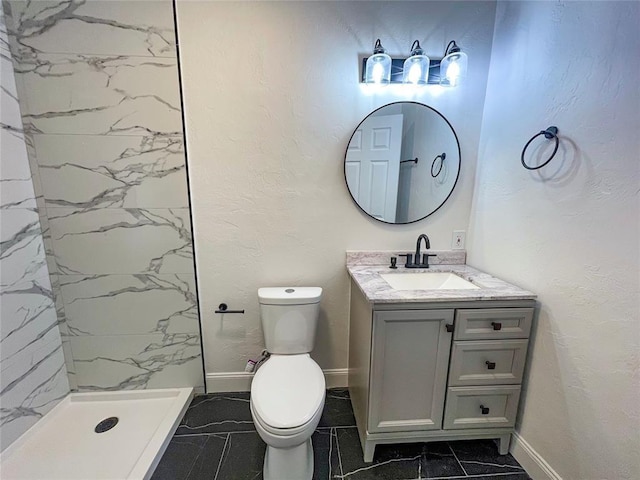 bathroom with vanity, toilet, and tiled shower