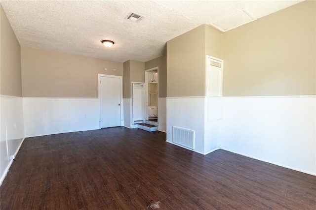 unfurnished room featuring a textured ceiling and dark wood-type flooring