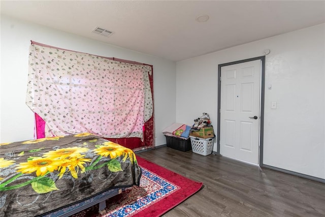 bedroom with dark hardwood / wood-style flooring