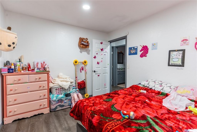 bedroom featuring ensuite bathroom and dark hardwood / wood-style flooring