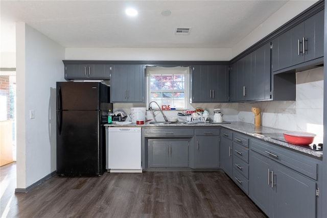 kitchen featuring sink, white dishwasher, gray cabinetry, black refrigerator, and dark hardwood / wood-style flooring