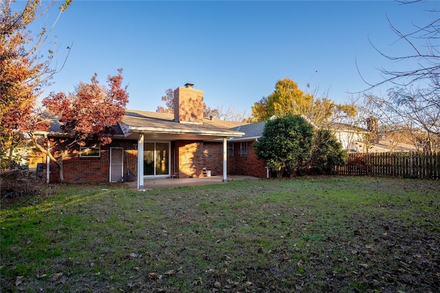 back of property with a patio area and a yard