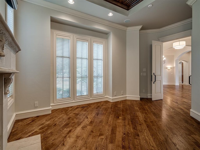 empty room featuring a healthy amount of sunlight, dark hardwood / wood-style flooring, and crown molding