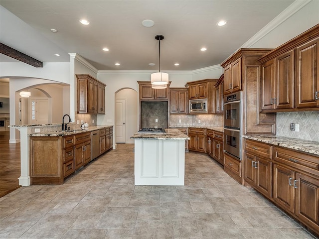 kitchen with pendant lighting, sink, appliances with stainless steel finishes, light stone counters, and kitchen peninsula