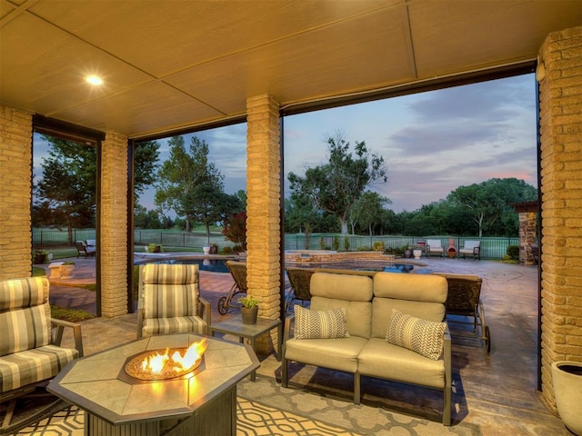 patio terrace at dusk featuring an outdoor living space with a fire pit