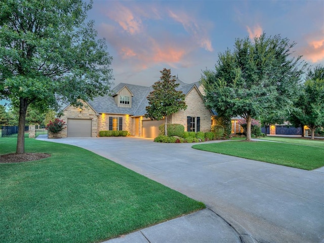 view of front of house featuring a garage and a lawn