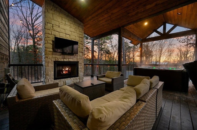 deck with an outdoor living space with a fireplace