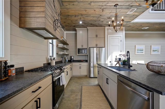 kitchen featuring appliances with stainless steel finishes, decorative light fixtures, finished concrete floors, open shelves, and a sink