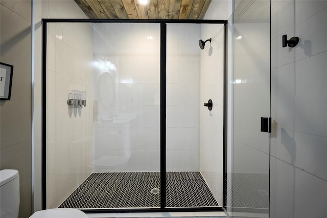 full bath featuring a stall shower and toilet