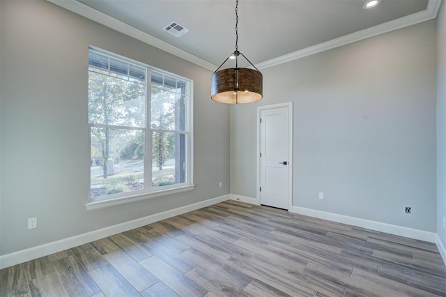 empty room featuring light wood-type flooring and crown molding