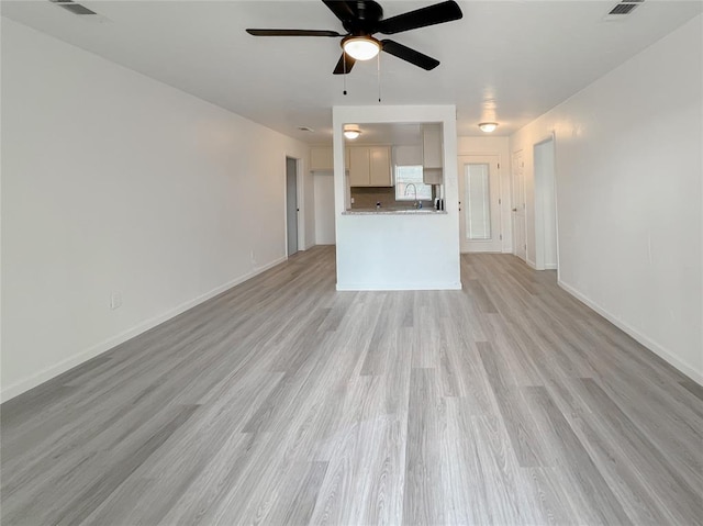 unfurnished living room with ceiling fan, light hardwood / wood-style flooring, and sink