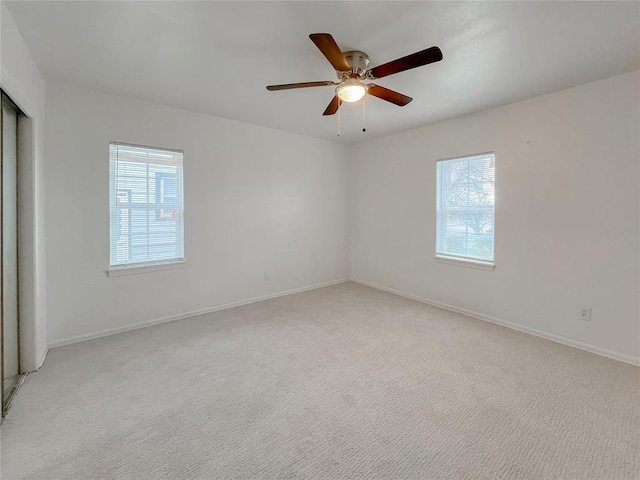 spare room featuring ceiling fan and light colored carpet