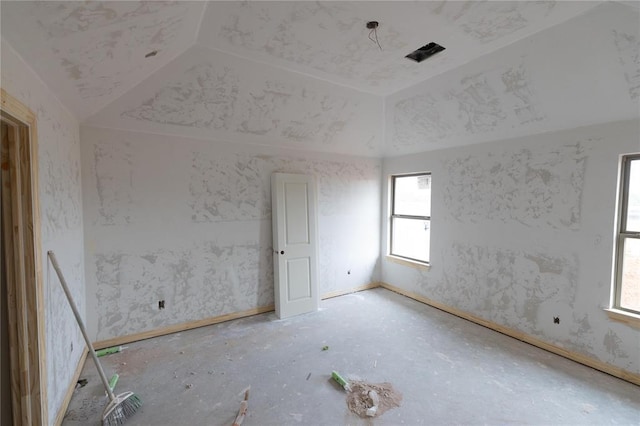 unfurnished room featuring lofted ceiling and baseboards